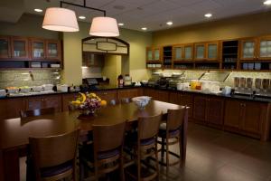 a kitchen with a large wooden table and chairs at Hyatt Place Grand Rapids South in Wyoming