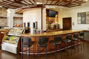 um bar num restaurante com bancos pretos em Hyatt Place Grand Rapids South em Wyoming