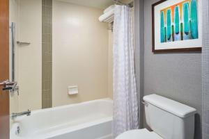 a bathroom with a white tub and a toilet and a shower at Hyatt Place Greensboro in Greensboro
