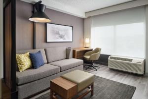 a living room with a couch and a desk at Hyatt Place Greensboro in Greensboro