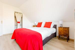 - une chambre avec un lit et une couverture rouge dans l'établissement Les Bécasses, à Merlimont