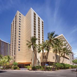 a building with palm trees in front of a street at Hyatt Place Waikiki Beach in Honolulu