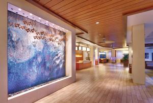 a hallway of a hospital with a large painting on the wall at Hyatt Place Waikiki Beach in Honolulu