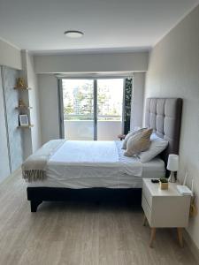 a bedroom with a large bed and a window at FLATS en Barranco in Lima