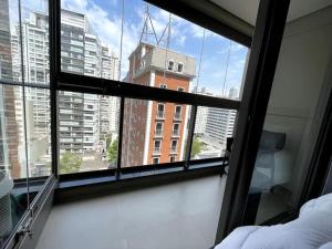 - une chambre avec vue sur un bâtiment depuis une fenêtre dans l'établissement Studio charmoso, próximo à Av. Paulista, à São Paulo