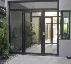 une porte en verre ouverte d'une maison ornée de plantes dans l'établissement Studio charmoso, próximo à Av. Paulista, à São Paulo