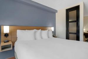 a bedroom with a large white bed and a door at Hyatt Place Houston-North in Houston