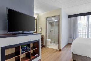 a hotel room with a flat screen tv and a bed at Hyatt Place Houston-North in Houston