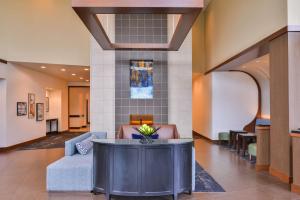 Hyatt Place Herndon Dulles Airport - East في هيرندون: لوبي فيه كنب وطاولة