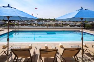 a swimming pool with chairs and umbrellas at Hyatt Place Long Island East End in Riverhead