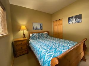 a bedroom with a bed and a night stand with a lamp at Morrisey Chalet at Sun Peaks in Sun Peaks