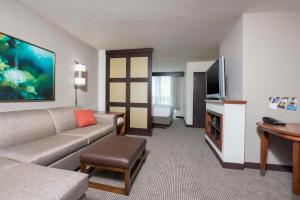 a living room with a couch and a flat screen tv at Hyatt Place Lexington in Lexington