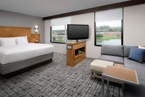 um quarto de hotel com uma cama e uma televisão de ecrã plano em Hyatt Place Sugar Land em Sugar Land