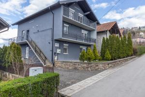 uma casa azul com uma parede de pedra em Apartman Albijanić em Sremska Kamenica