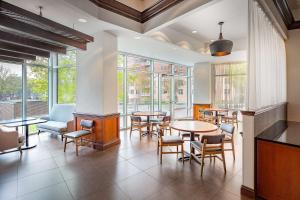 a restaurant with tables and chairs and windows at Hyatt Place Madison/Downtown in Madison