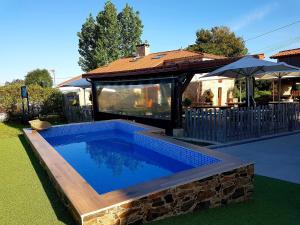 a swimming pool in a yard next to a house at Albergue El Aleman in Boente