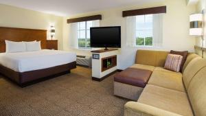 a hotel room with a bed and a flat screen tv at Hyatt Place Coconut Point in Estero