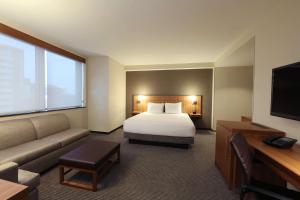 um quarto de hotel com uma cama e um sofá em Hyatt Place Flushing/LGA Airport em Queens