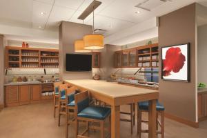 una cocina con una gran mesa de madera y sillas en Hyatt Place New York/Midtown-South, en Nueva York