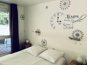 1 dormitorio con 1 cama y reloj en la pared en Du côté de chez Sam, en Andelaroche