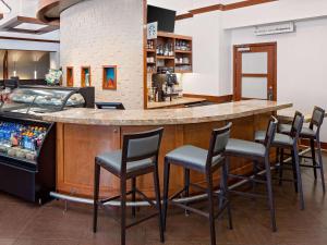 a bar in a restaurant with chairs around it at Hyatt Place Ontario/Rancho Cucamonga in Ontario