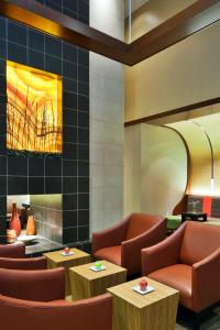 a waiting room with chairs and tables and a painting at Hyatt Place Chesapeake in Chesapeake