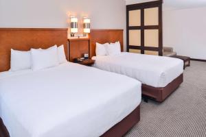 two beds in a hotel room with white sheets at Hyatt Place Chesapeake in Chesapeake