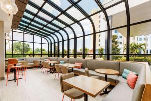 un restaurante con mesas, sillas y ventanas en Hyatt Place across from Universal Orlando Resort en Orlando