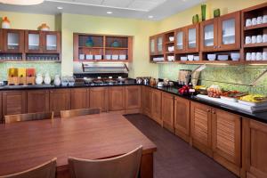 a large kitchen with wooden cabinets and a table at Hyatt Place Phoenix/ Mesa in Mesa