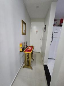 une petite table dans un couloir avec un réfrigérateur dans l'établissement HollydayAppartment no Centro Rio das Ostras, à Rio das Ostras