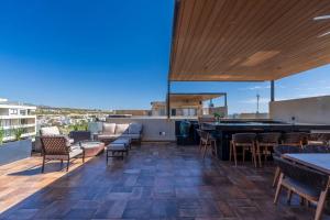 a patio with a bar and tables and chairs at New Luxury PH 4BR Cabo in Cabo San Lucas