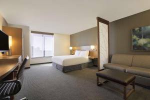 a hotel room with a bed and a couch at Hyatt Place Salt Lake City/Cottonwood in Cottonwood Heights