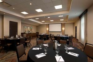 a conference room with tables and chairs and a screen at Hyatt Place Manati in Manati