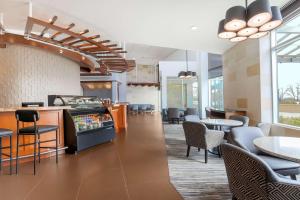 a lobby with tables and chairs and a restaurant at Hyatt Place UC Davis in Davis