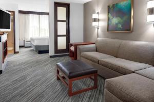 a hotel room with a couch and a bed at Hyatt Place Tampa Busch Gardens in Tampa