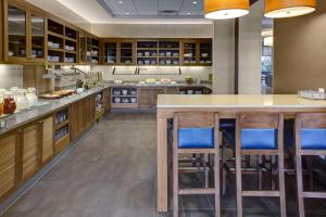 a kitchen with wooden cabinets and a large island with bar stools at Hyatt Place Columbus in Columbus