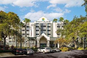 ein Hotel mit Autos auf einem Parkplatz in der Unterkunft Hyatt Place Tampa Busch Gardens in Tampa