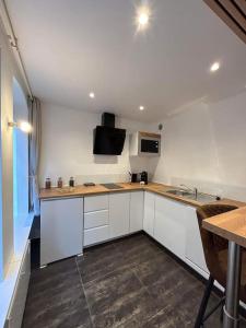 a kitchen with white cabinets and a counter top at Love Room: Parenthese romantique in Barr