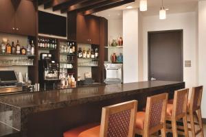 - un bar avec des chaises et un comptoir avec des bouteilles d'alcool dans l'établissement Hyatt Place Buffalo / Amherst, NY, à Amherst