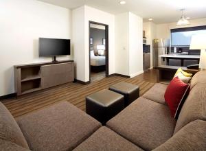 a living room with a couch and a television at Hyatt House Pittsburgh Bloomfield Shadyside in Pittsburgh