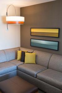 a couch in a living room with yellow pillows at Hyatt Place Charleston - Historic District in Charleston