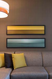 a brown couch with yellow pillows in a room at Hyatt Place Charleston - Historic District in Charleston