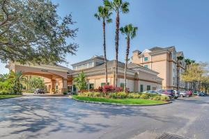 um grande edifício de apartamentos com palmeiras e uma entrada em NEW in Lake Buena Vista 1 mile to Disney Springs em Orlando