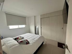 Un pat sau paturi într-o cameră la Apartamento ciudad Jardin Barranquilla