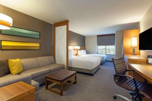 a hotel room with a bed and a couch at Hyatt Place Chicago Midway Airport in Bedford Park
