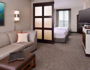 a hotel room with a couch and a bed at Hyatt Place Garden City in Garden City