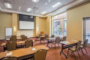 ein Klassenzimmer mit Tischen, Stühlen und einer Leinwand in der Unterkunft Hyatt Place Cleveland/Westlake/Crocker Park in Westlake