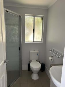 a bathroom with a toilet and a window and a shower at Mandurah Coastal Holiday Park in Mandurah
