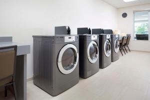 una fila de lavadoras en una lavandería en Hyatt House Dallas / Frisco en Frisco