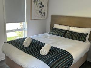 Mandurah Coastal Holiday Park في ماندورا: غرفة نوم عليها سرير وفوط